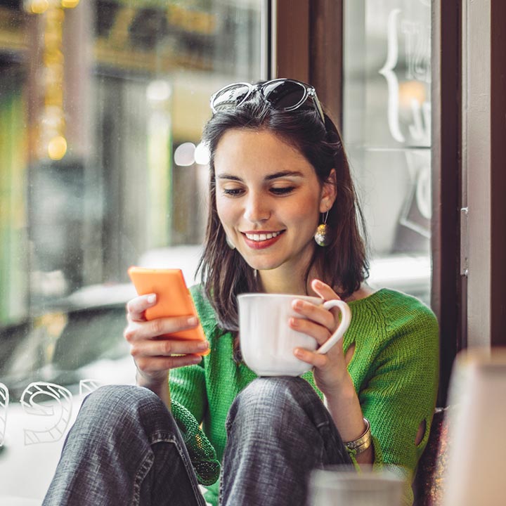 Lady in a coffee shop using a smartphone